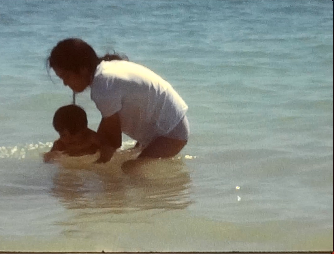 Ma mère et moi, enfant, jouant dans l'eau peu profonde d'une plage de l'île Maurice.