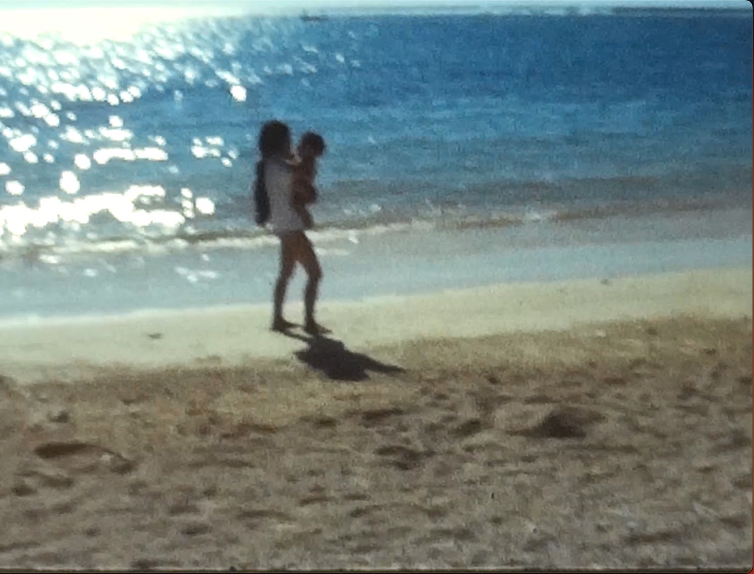 Ma mère me portant face à l'océan Indien, sur une plage de l'île Maurice, alors que je n'avais pas encore un an.